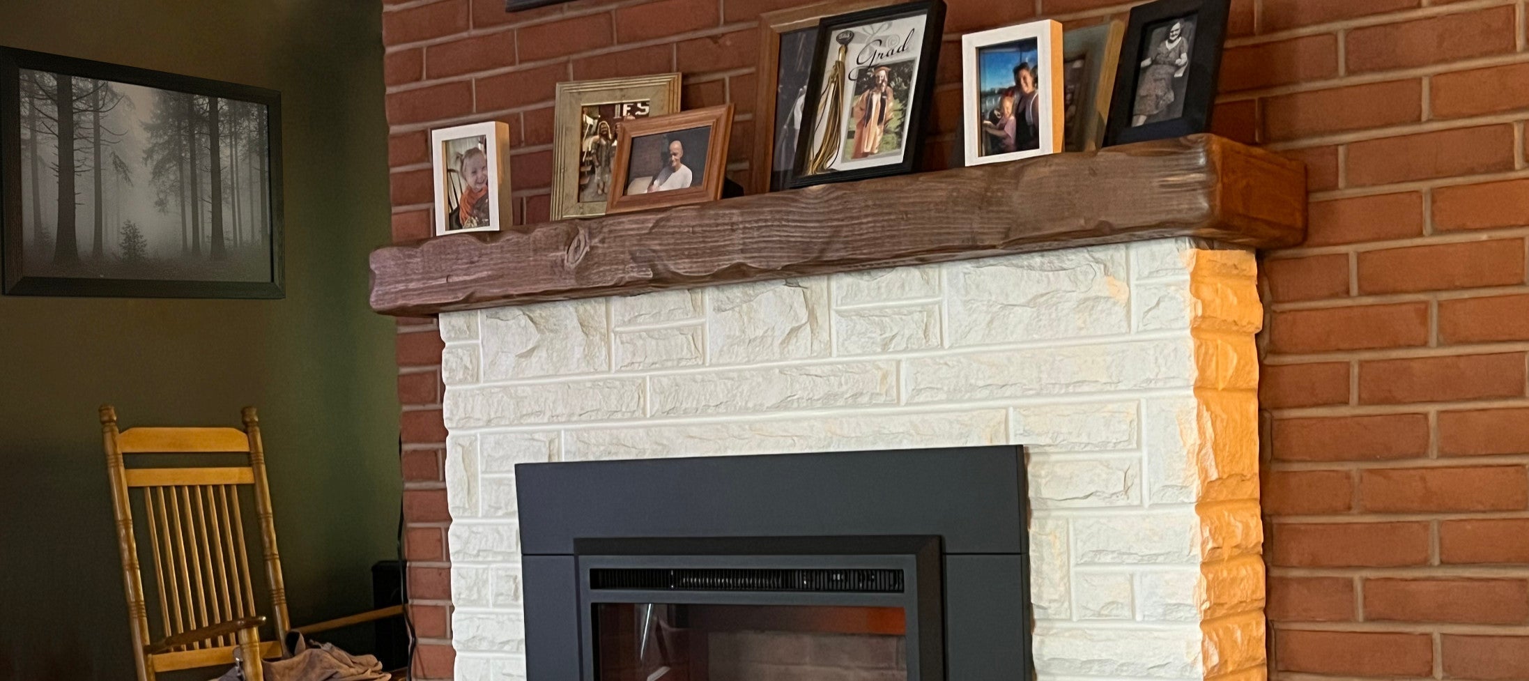 A rustic mantel cover on a stone and brick fireplace